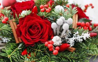 Christmas decoration with red roses, fir, brunia and cinnamon sticks. Festive decor