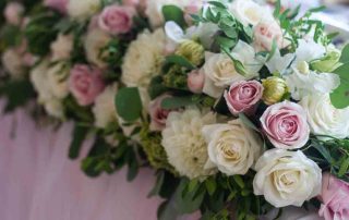 Wedding table decoration with pink and white tender roses. Floral decorations design. Selective focus.